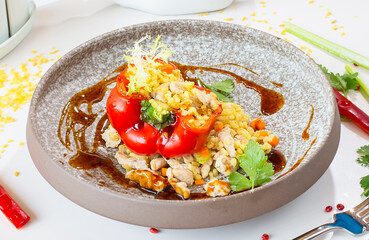 Chicken breast with bulgur baked in pepper in a gray ceramic plate in a restaurant. Selective focus. Super short focus