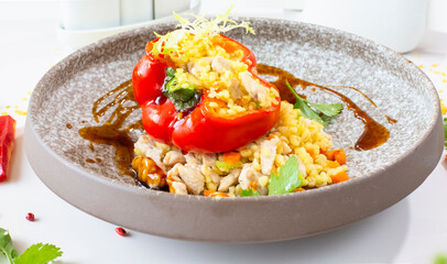 Chicken breast with bulgur baked in pepper in a gray ceramic plate in a restaurant. Selective focus. Super short focus
