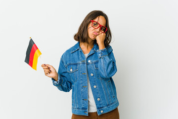 Young latin woman holding a german flag isolated on white background