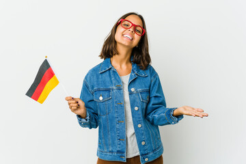 Young latin woman holding a german flag isolated on white background