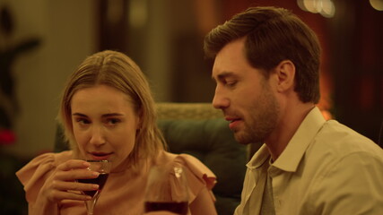 Man and woman drinking wine at table. Positive couple flirting at date