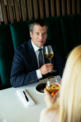 Handsome businessman dressed in the suit drinking wine. Businessman enjoying in the restaurant