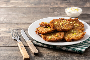 Traditional Jewish latkes or potato pancakes on wooden table.Copy space