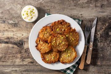 Traditional Jewish latkes or potato pancakes on wooden table.Top view
