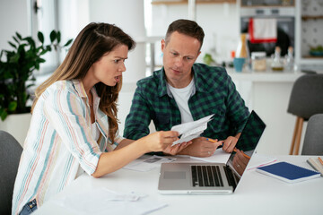 Husband and wife preparing bills to pay. Young couple having financial problems..