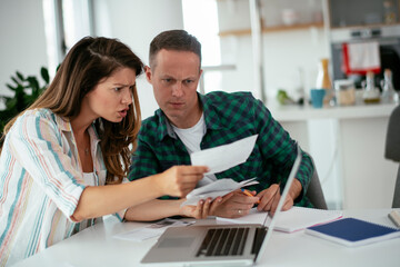Husband and wife preparing bills to pay. Young couple having financial problems..