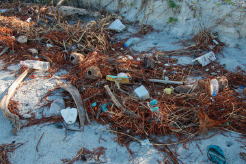 Beach plastic pollution. Plastic bottles and other trash on the beach sands.