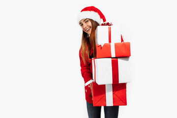 beautiful brunette in red sweater and Santa Claus hat holding many gifts on white background, Christmas, holiday concept