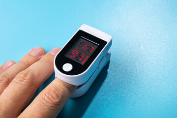 White new pulse oximeter on a blue table