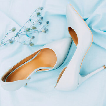 Beautiful blue high heel shoes. Flat lay, top view on blue background. Beauty blog concept. Pale blue female shoes. Blue wedding