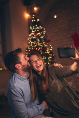Fototapeta na wymiar Couple taking a selfie on Christmas Eve