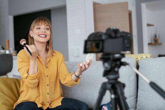 Female vlogger recording makeup tutorial for her channel. Young beautiful woman recording make up tutorial to share on social media..