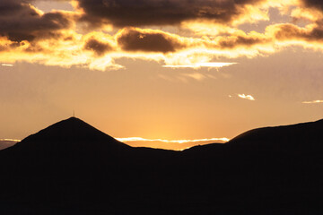 Beautiful aerial landscape of mountain peak at sunset above the clouds - panoramic