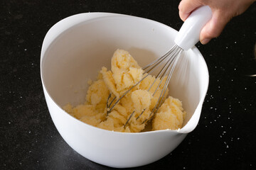 Whisking butter prepating cup cakes following a recipe
