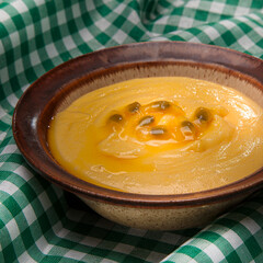 Passion fruit mousse on a white plate with open fruit in the background