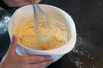 Whisking butter prepating cup cakes following a recipe
