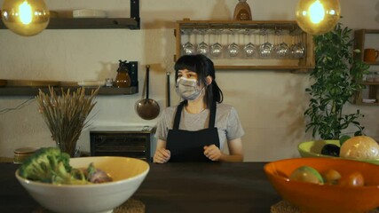 Caucasian waitress wearing protective face mask giving bag to customer in a restaurant. Young woman worker working with take away orders during corona virus outbreak. Concept food and drinks takeaway.