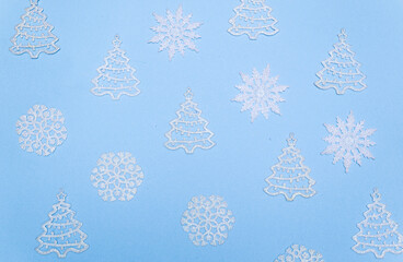 Christmas trees and snowflakes on a sky-blue background. The view from the top.
