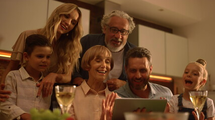 Family waving hands at camera during video call. People video chatting online