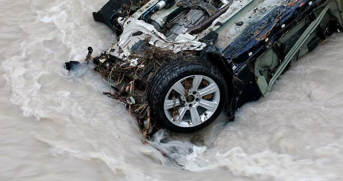 Wheel Of A Destroyed Sports Car In The Roya River During Storm Alex In France, Europe. Close Up View - DCi 4K Resolution
