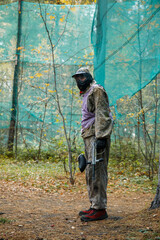 a man in the woods playing paintball