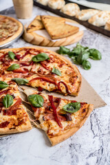 delicious homemade pizza with sauce, cheese ready to eat on white marble