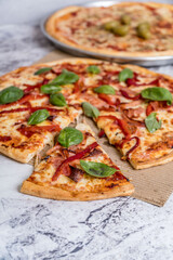delicious homemade pizza with sauce, cheese ready to eat on white marble
