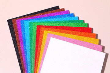 Several colored paper decorated with glitter are shown in different designs.