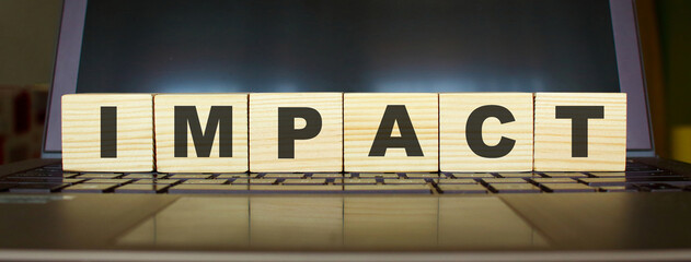 Wooden cubes with letters on a laptop keyboard.