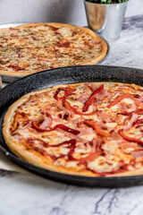 delicious homemade pizza with sauce, cheese ready to eat on white marble