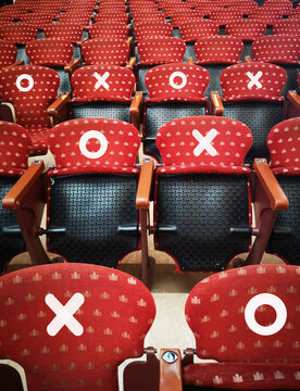 Rows of empty red cinema chairs in a theatre during the period of the covid-19, corona virus. Social distancing