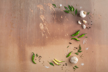 Spicy vegeterian composition with green pepper, garlic, greens and spices on vintage background. Top view, copy space, design.