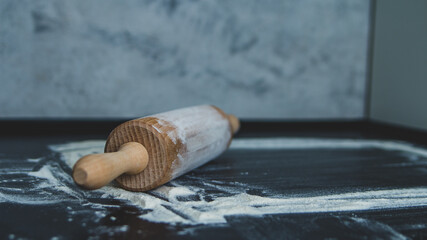 Fototapeta Wałek do ciasta z mąką na ciemnym czarnym tle do pieczenia obraz