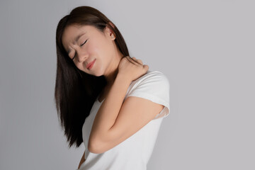 Close up of tired Asian woman. She used her hands to touch the neck on isolated background.