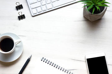 White desk office with laptop, smartphone and other work supplies with cup of coffee. Top view with copy space for input the text. Designer workspace on desk table essential elements on flat lay