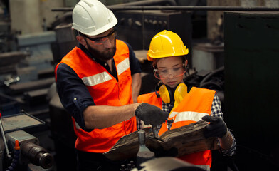 Men and female workers in factory operating machine in workshop floor.