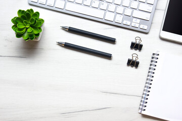 White desk office with laptop, smartphone and other work supplies with cup of coffee. Top view with copy space for input the text. Designer workspace on desk table essential elements on flat lay