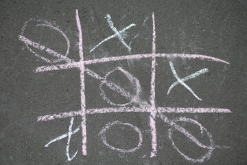 Noughts and crosses drawn with crayons on the asphalt