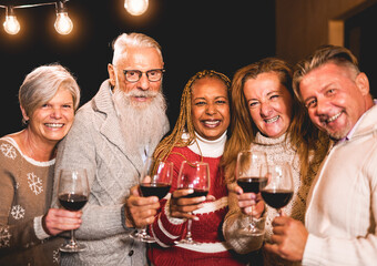 Happy multiracial senior people celebrate christmas together - Portrait of friends outdoor with vintage lights