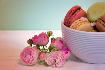 Macarons in the white ceramic bowle with the rose
