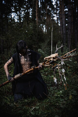 Sorcerer with marks on his body in the forest
