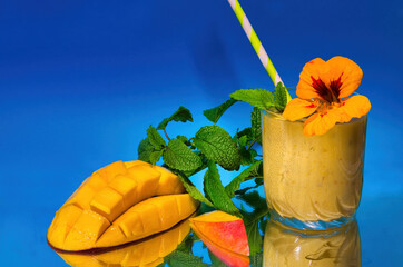Mango lassi with cutted mango, herbs and straw