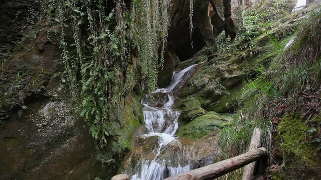 Beautiful waterfalls in a rocky gorge full of vegetation, Caglieron Caves, Italy. Video that inspires tranquility and light-heartedness in nature