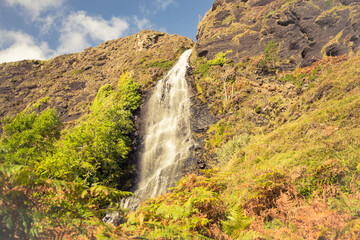 Obraz premium Tiny waterfall on the way to abandoned village Boreraig on the Isle of Skye