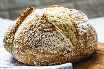 Fresh baked loaf of bread. Rustic sourdough bread on a napkin. Close up. Selective focus.