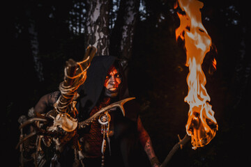 Sorcerer with marks on his body in the forest