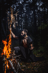 Sorcerer with marks on his body in the forest