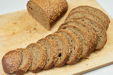 Fresh homemade baked bread and sliced bread on rustic white wooden cutting board