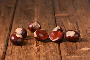 Raw chestnuts on a wooden table.