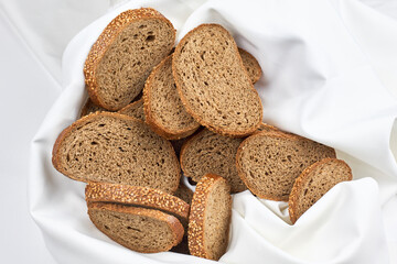Pile of loaf bread slices on white fabric textile with copy space